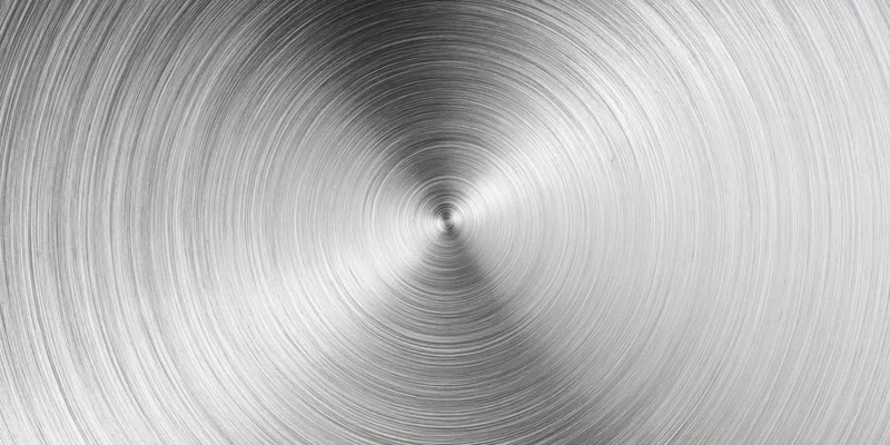 Close-up of a brushed metal surface with circular radial texture