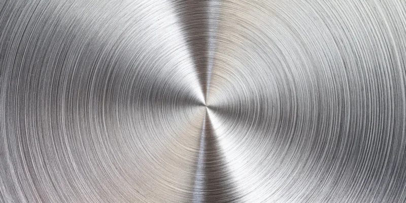 Close-up of a brushed metal surface with circular radial texture