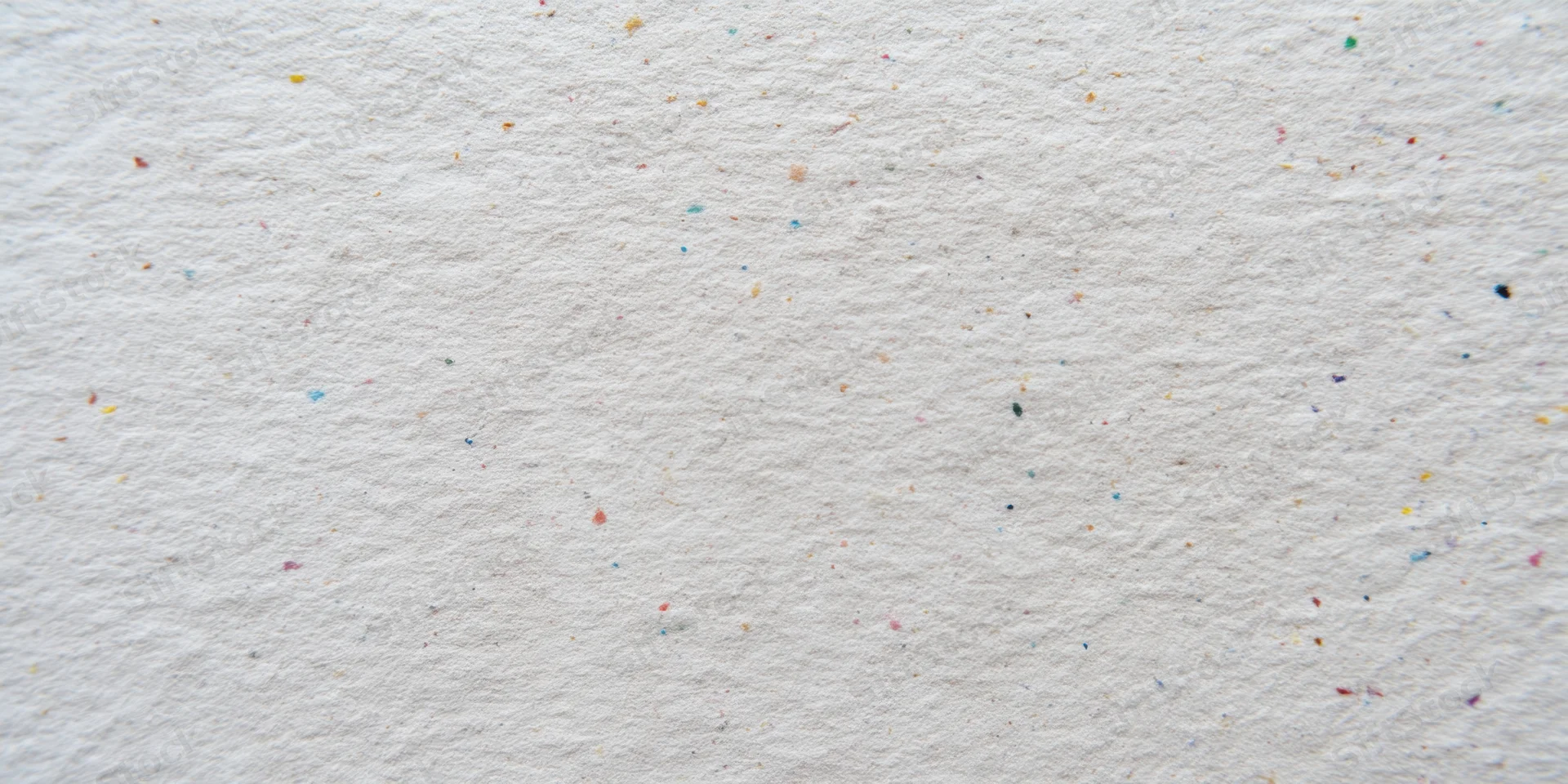 Close-up of textured off-white paper surface with scattered multicolored speckles