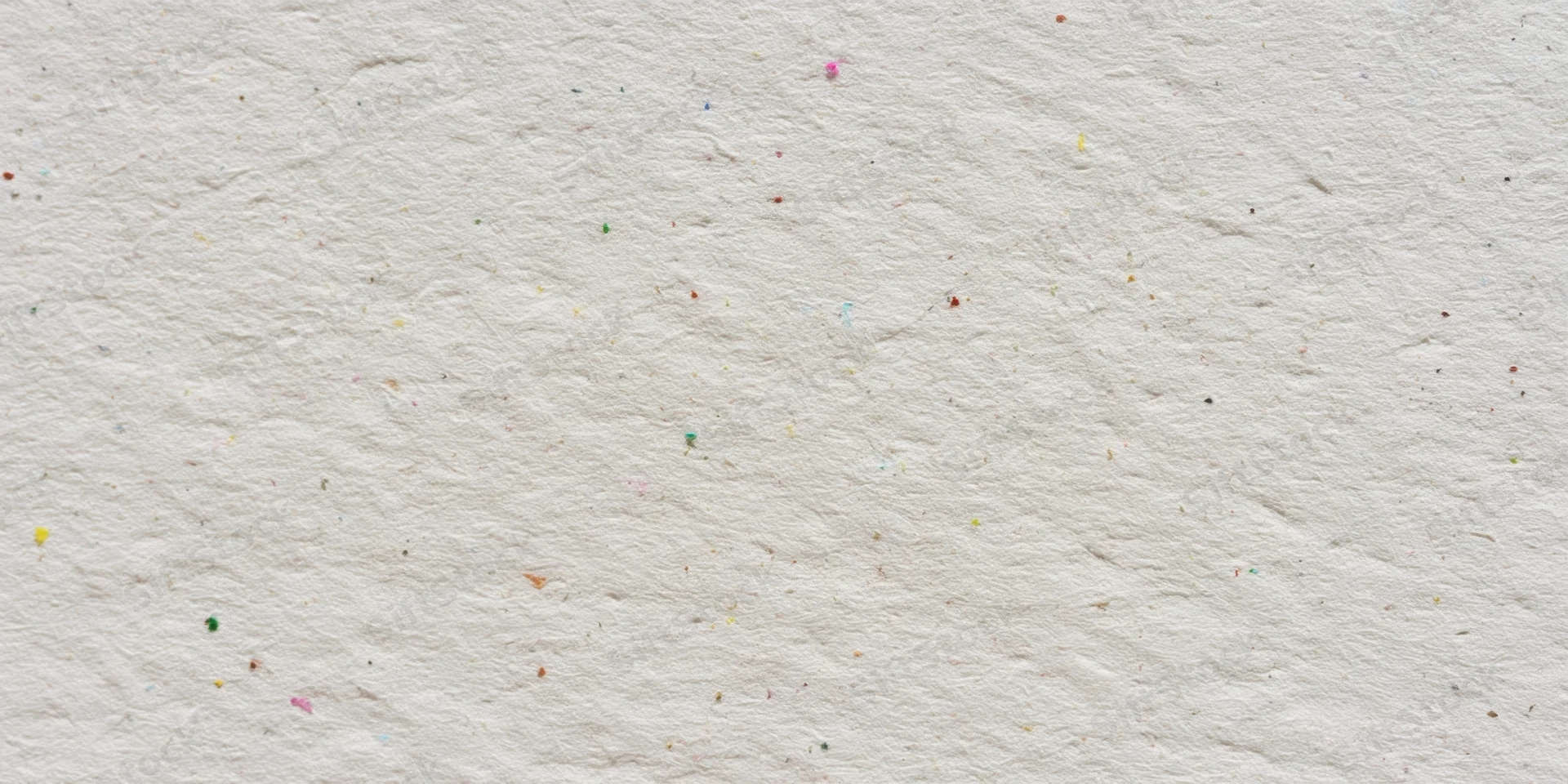Close-up of textured off-white paper surface with scattered multicolored specks
