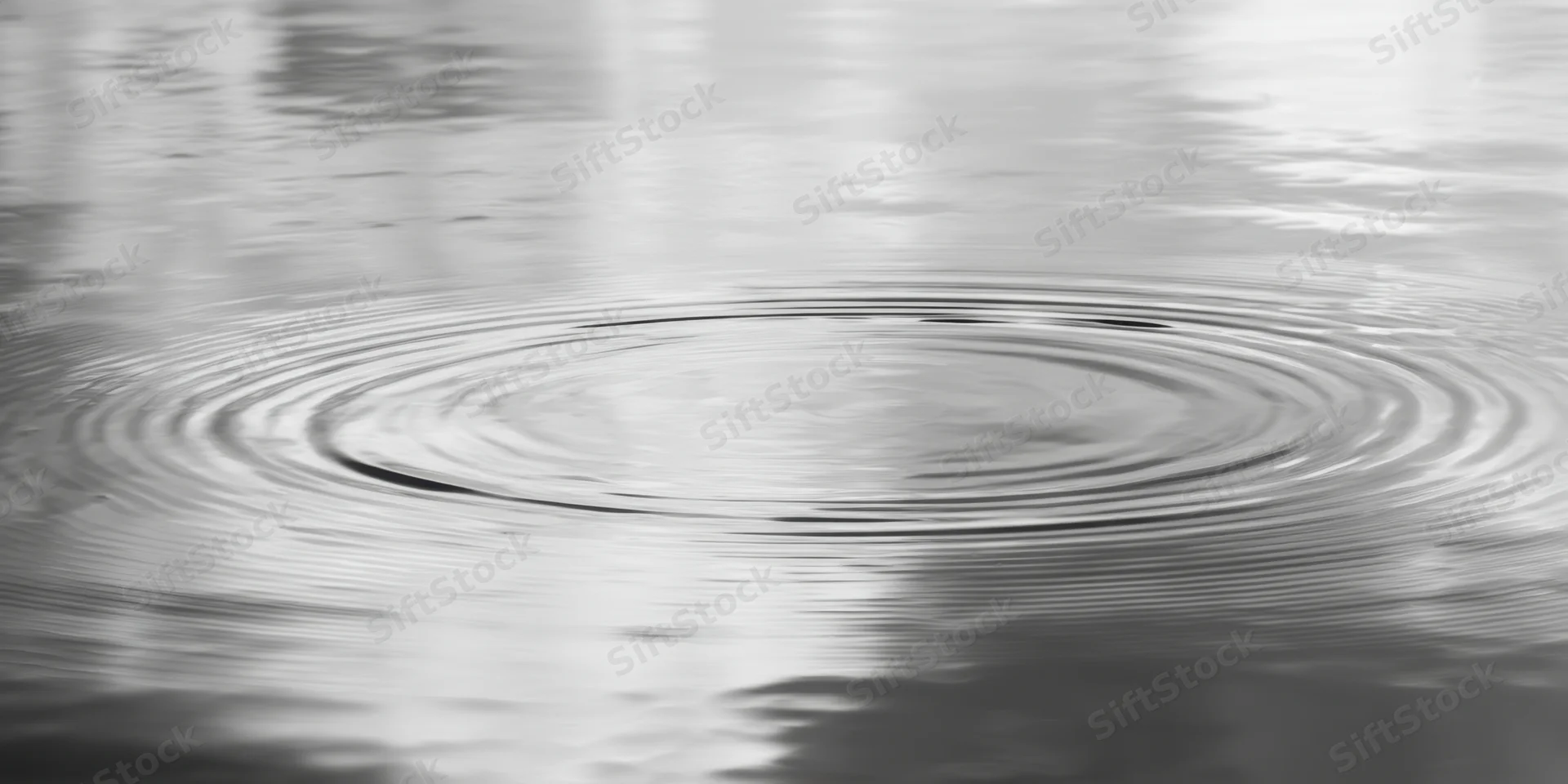 Concentric ripples spreading across calm water surface