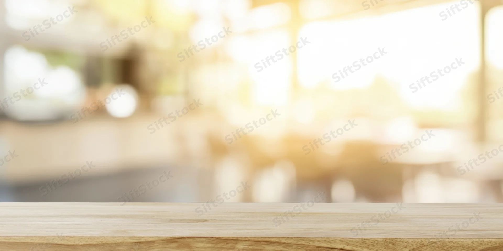 Light wooden tabletop in foreground with blurred restaurant interior background