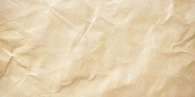 Pale beige parchment with subtle wrinkles and creases filling the frame