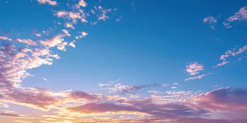 Sunrise sky with soft pink and orange clouds against a blue gradient horizon