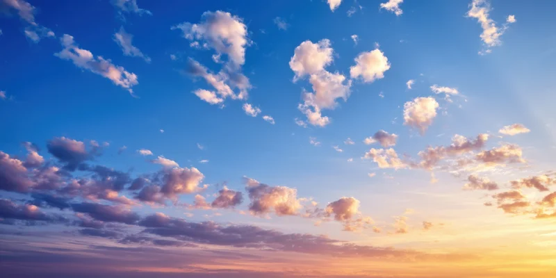 Sky with scattered clouds transitioning from cobalt blue to warm orange at sunrise