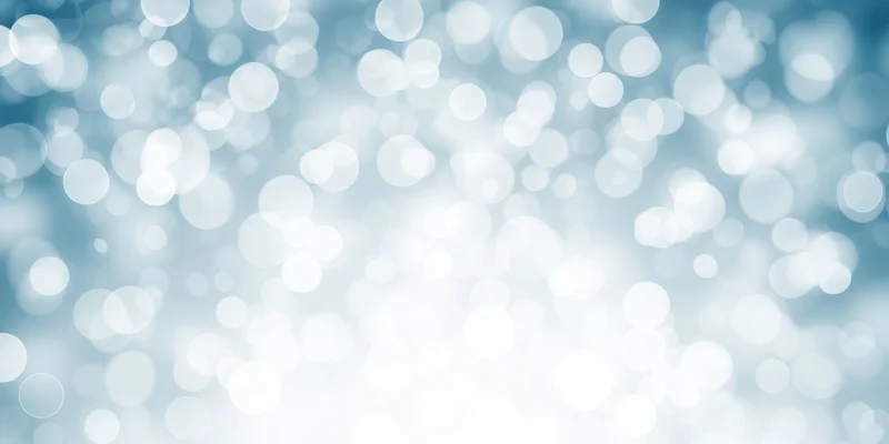 Soft blue and white bokeh background with circular light patterns