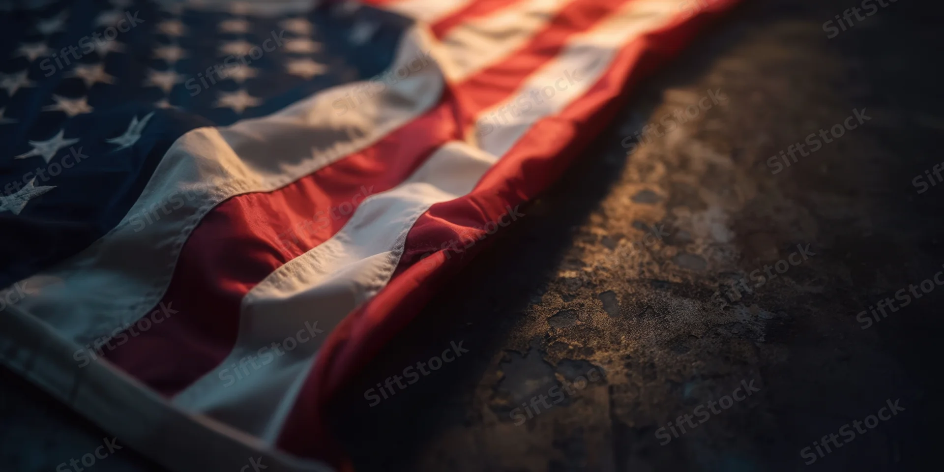 American flag folded along left edge resting on dark textured surface