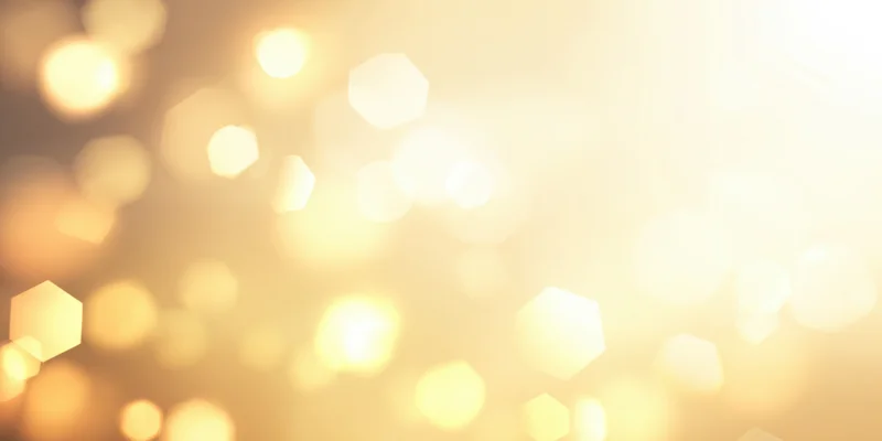 Warm golden bokeh lights in soft focus creamy gradient background