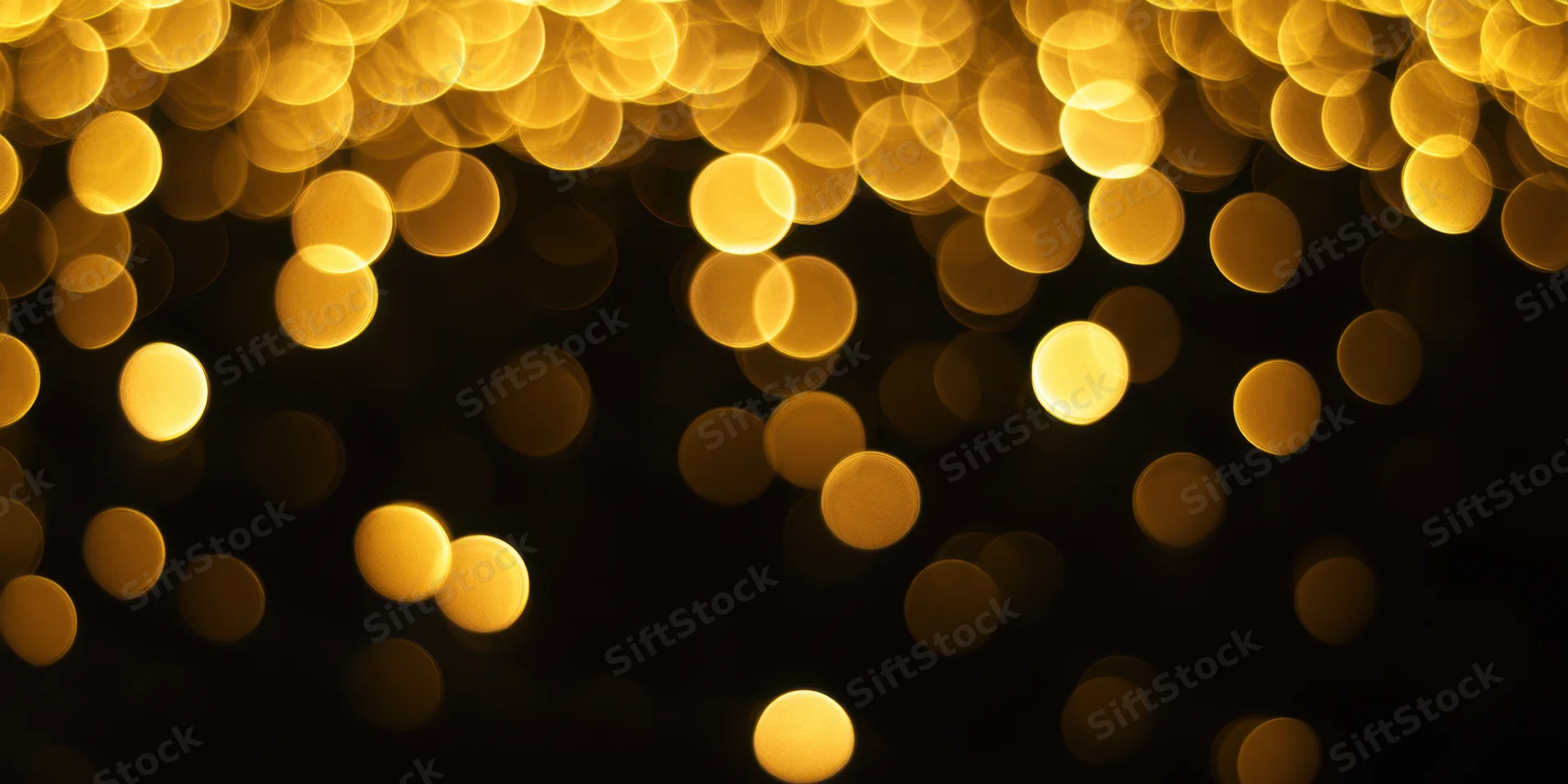 Warm golden bokeh lights scattered across a black background creating a festive ambiance