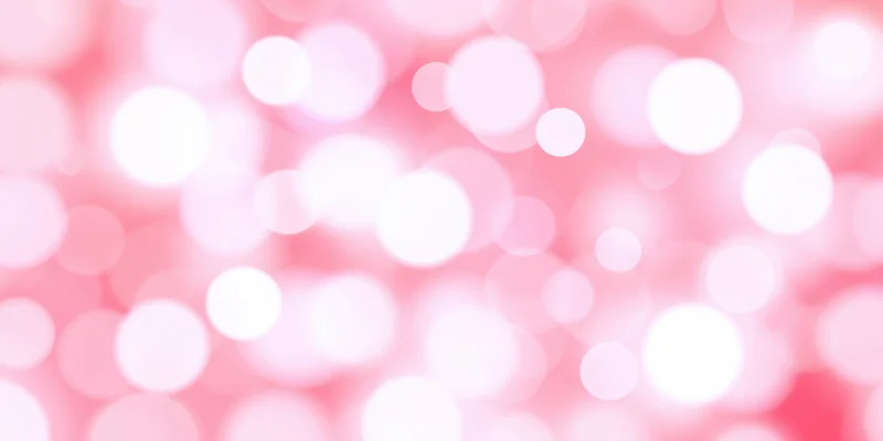 Soft pink bokeh background with glowing circular light orbs scattered across the frame