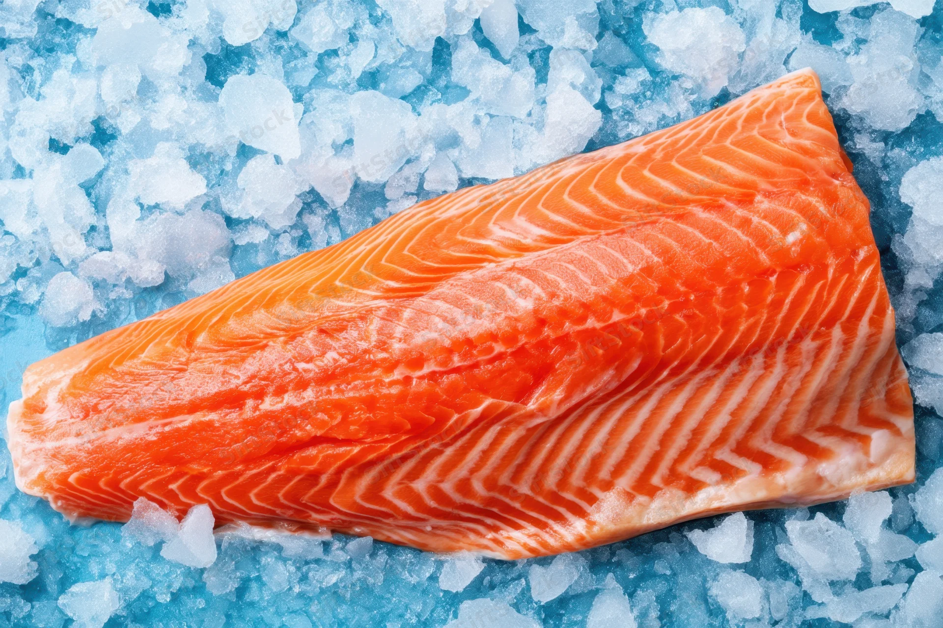 Fresh salmon fillet resting on crushed ice with vibrant orange flesh and white fat striations