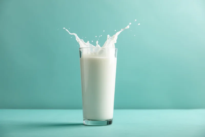 Featuring a glass of milk with a splash effect the glass is tall