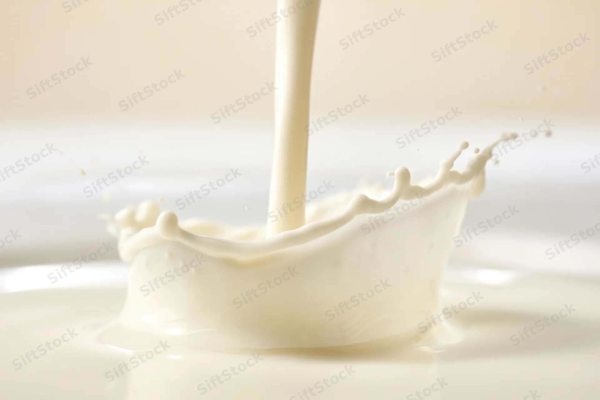 Milk being poured into a pool creating a splash crown on a smooth surface
