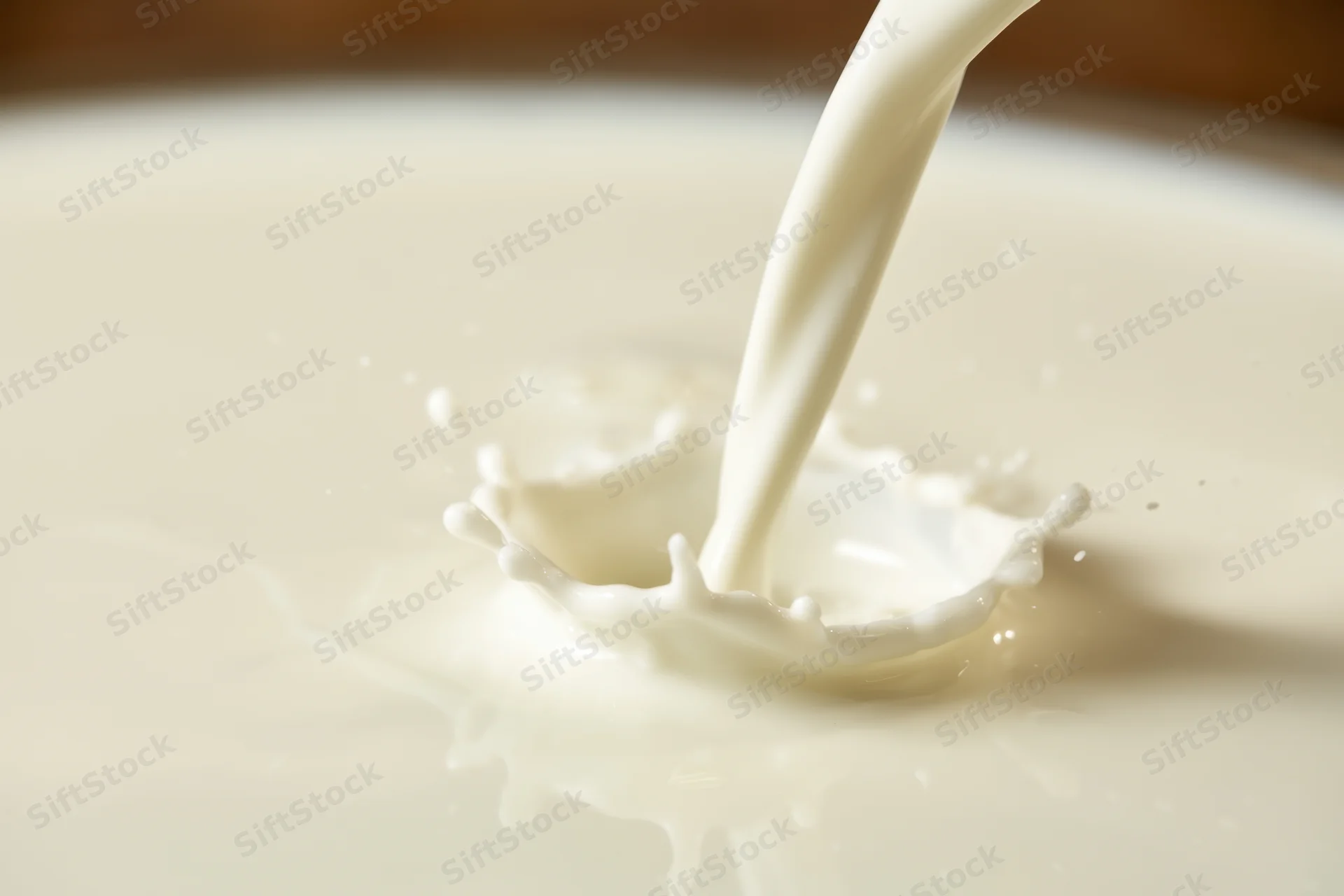 Milk being poured into a bowl creating a splash and crown effect