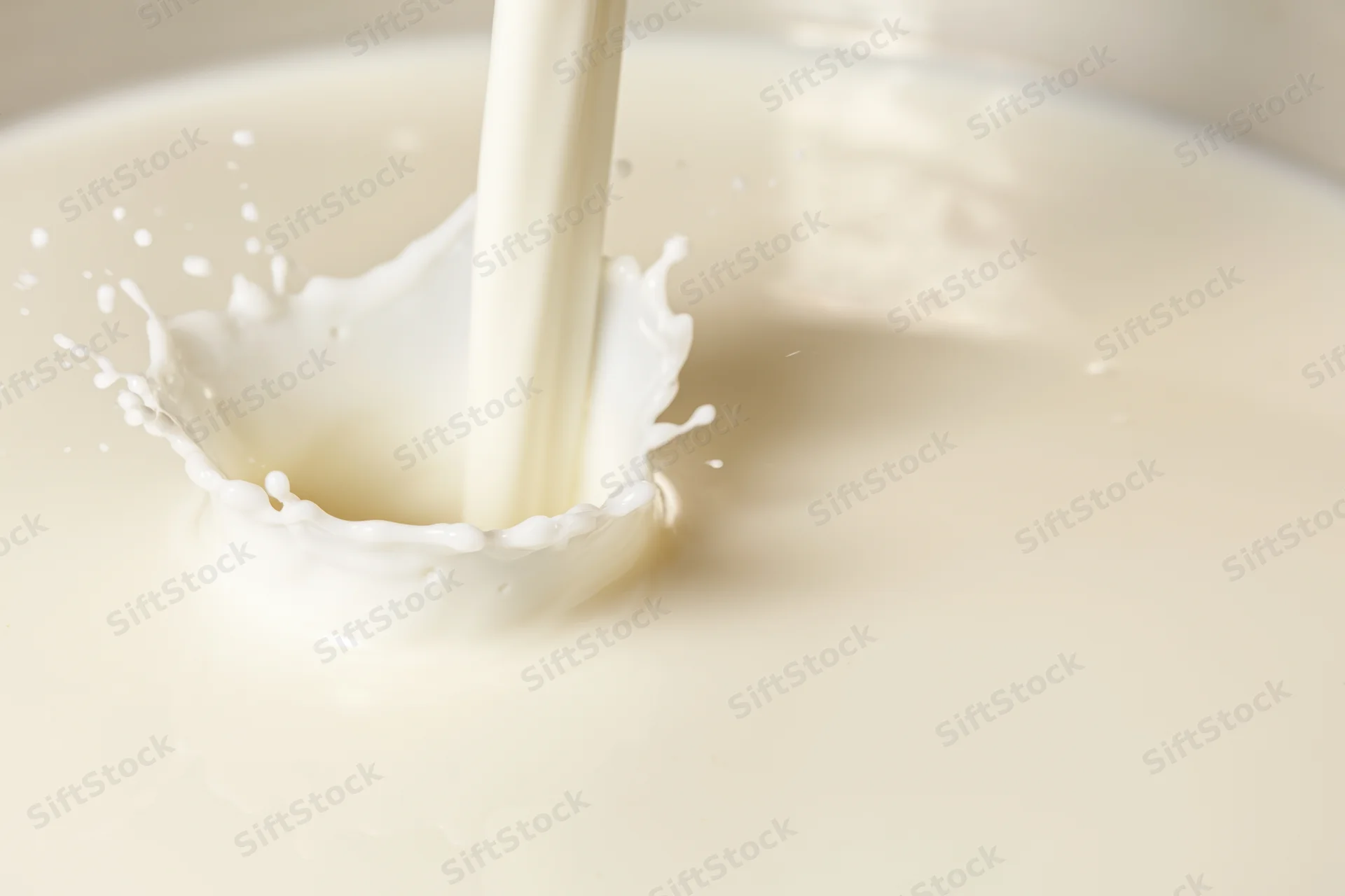 Milk being poured into a pool creating a splash and ripple effect