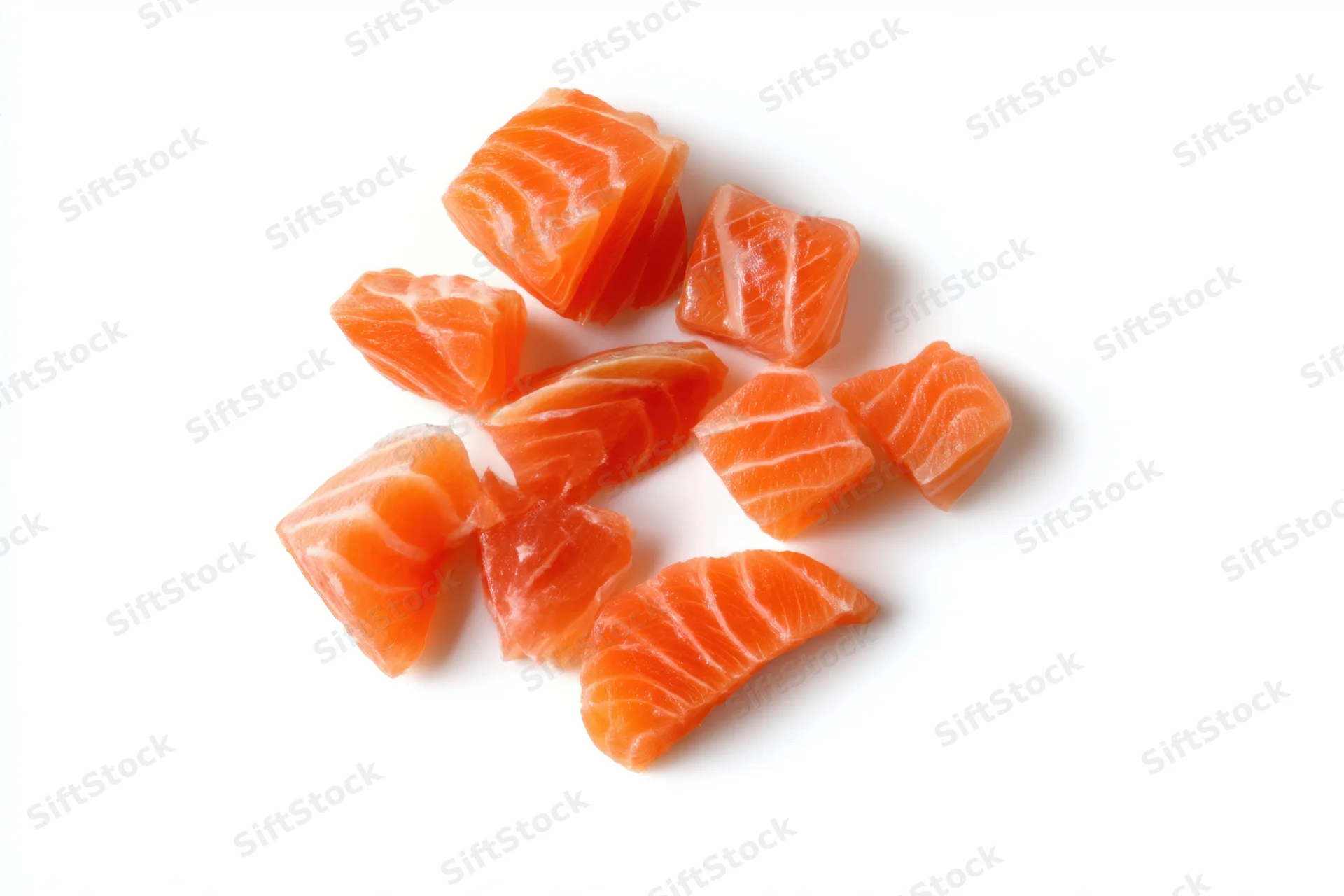 Raw salmon chunks arranged on a white background with copyspace