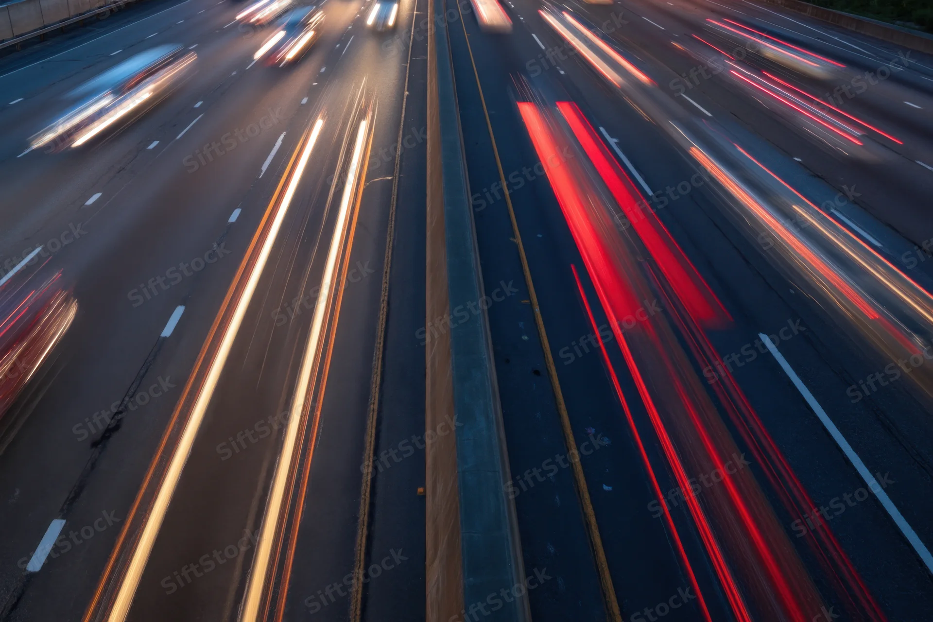 Highway traffic at dusk with moving vehicles creating light streaks from long exposure