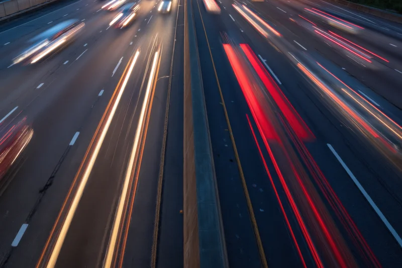 Highway traffic at dusk with moving vehicles creating light streaks from long exposure