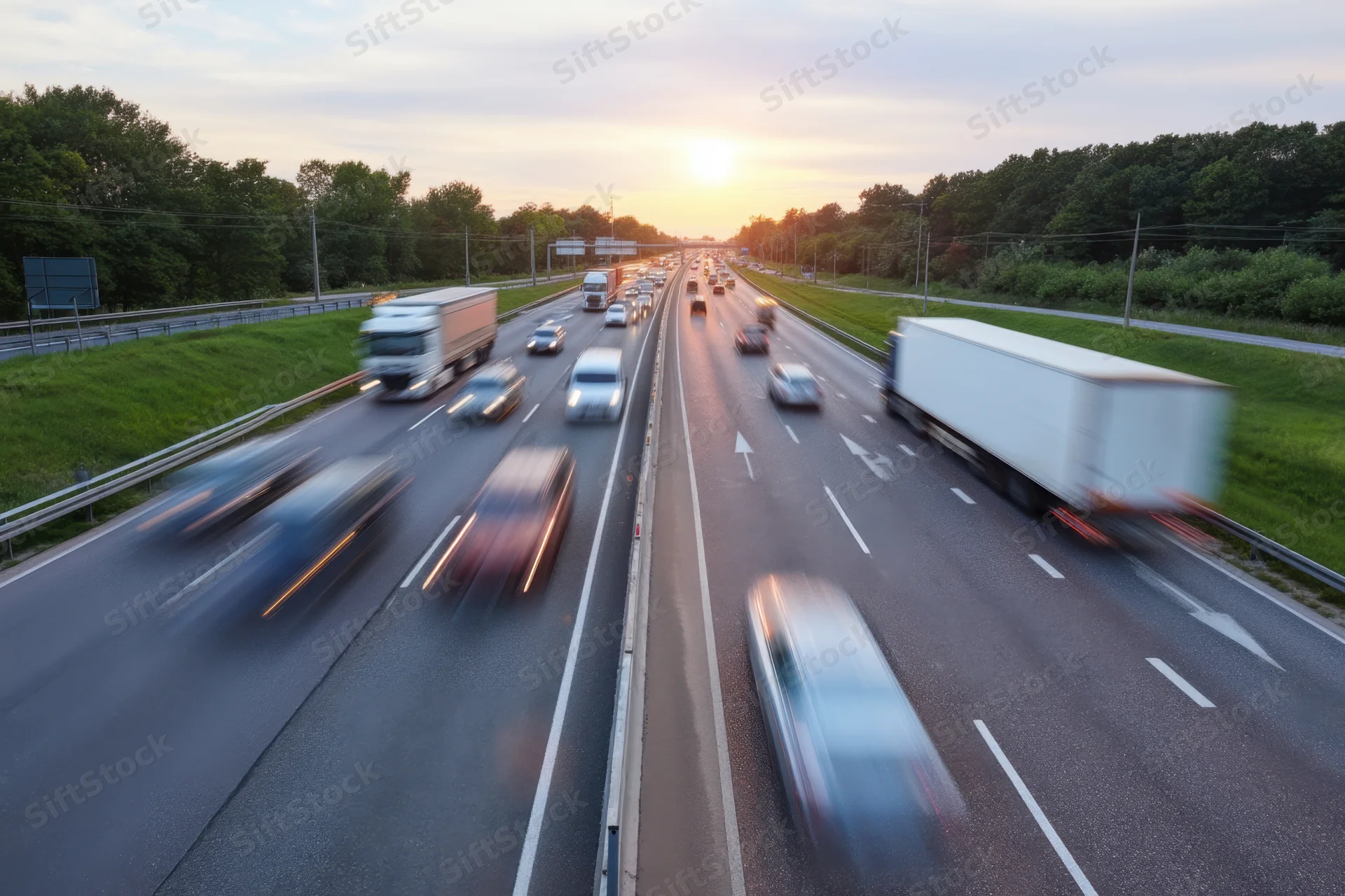 Vehicles in motion on a multi-lane highway at sunset