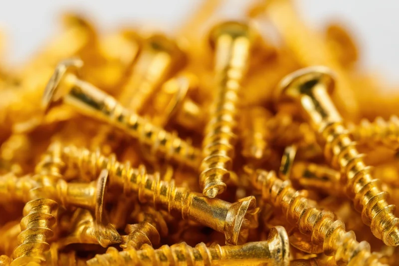 Closeup of golden screws piled together in a heap