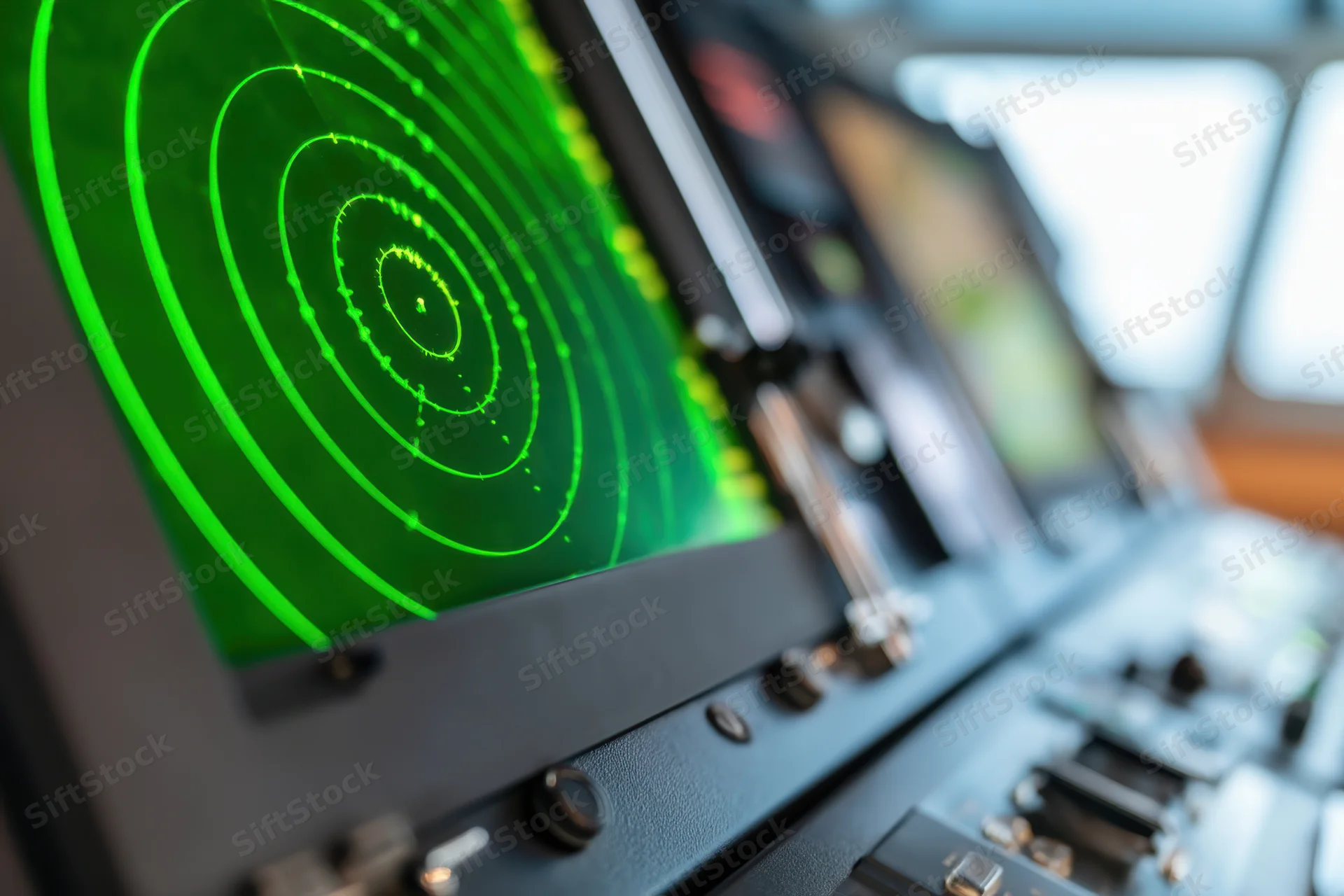 Close-up of a green radar display showing concentric circles and blips on a ship's bridge control panel