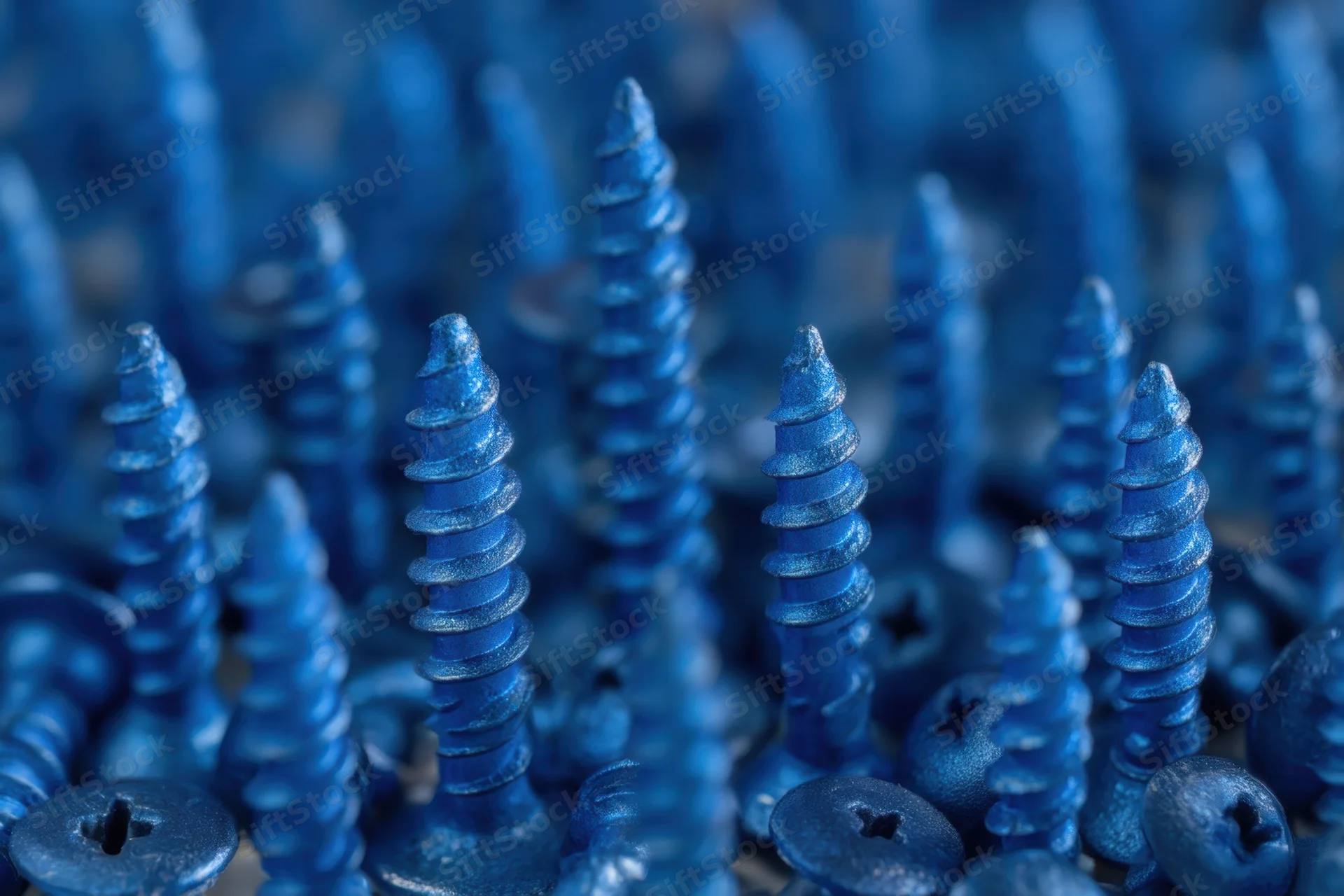 Dense arrangement of blue metallic screws with matte finish in close-up view