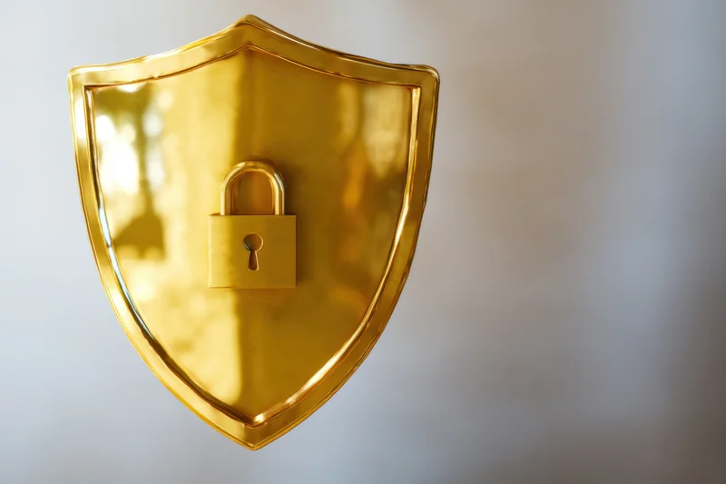 Golden shield with padlock symbol centered on plain background