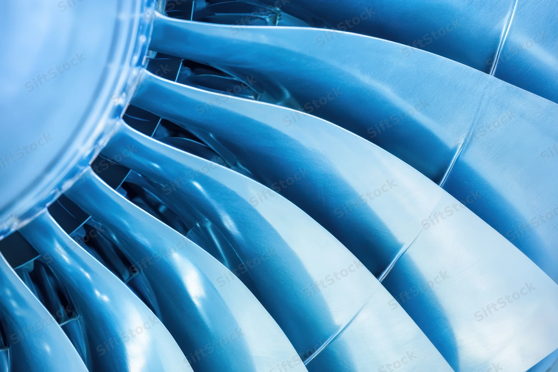 Close-up of jet engine turbine blades arranged in circular pattern showing metallic surface and curved structure