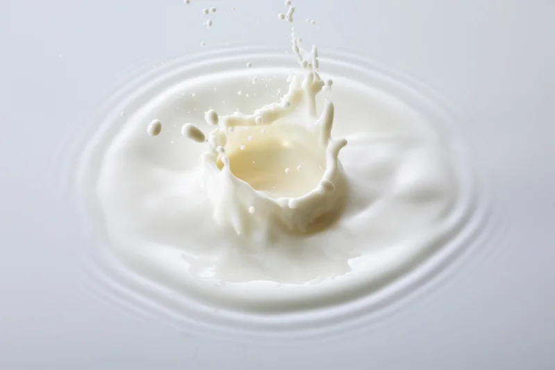 Milk splash captured in mid-action with droplets flying