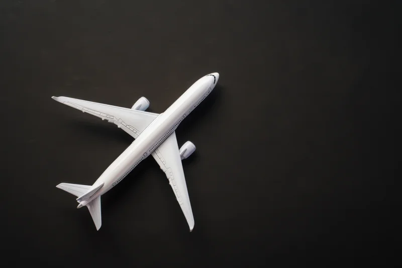 White model airplane positioned flat on matte black surface