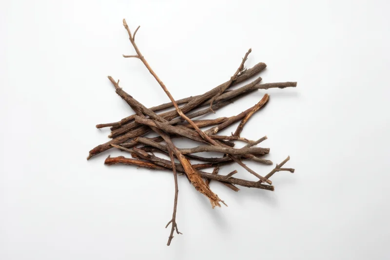 Pile of dry twigs and branches arranged on white surface