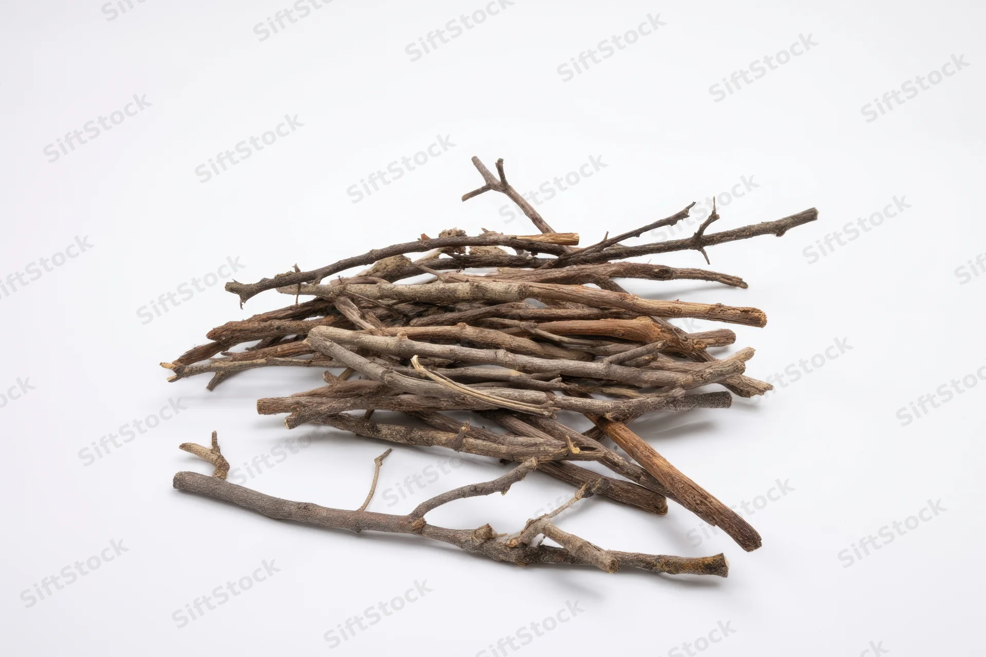 Pile of dry twigs and branches arranged on a white surface