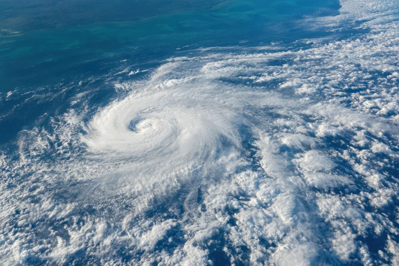 Powerful hurricane swirling over ocean with spiral cloud pattern and visible eye wall