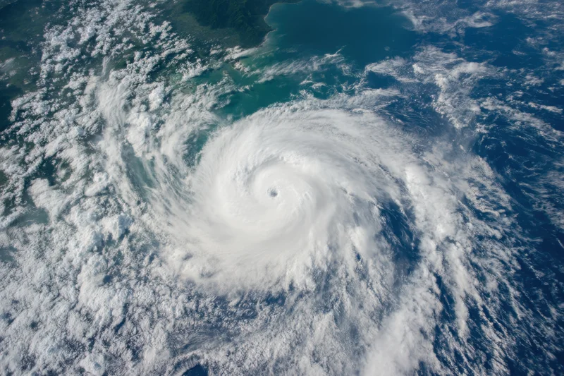 Powerful hurricane swirling over ocean with visible eye and spiral cloud pattern from satellite view