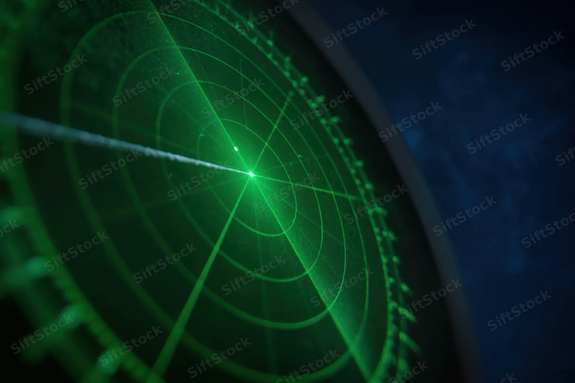 Green radar display showing circular grid and moving signal beam in dark environment