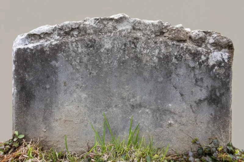 Weathered gravestone standing in grassy ground at cemetery