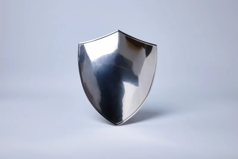 Polished metallic shield standing upright on a white surface