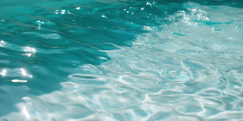 Close-up of turquoise pool water with sunlit ripples sparkling on the surface
