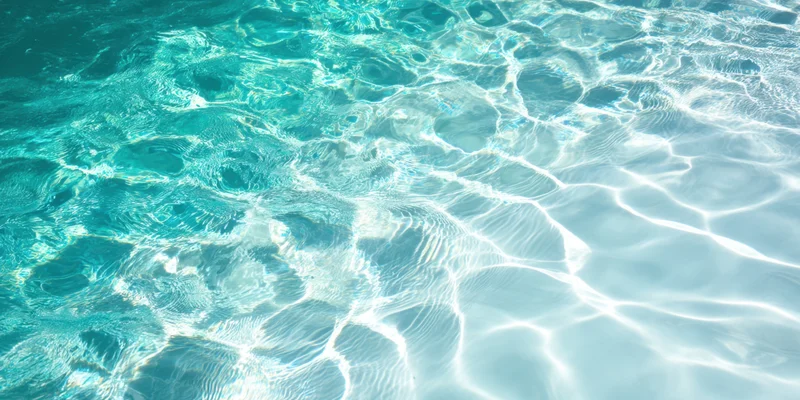 Turquoise pool water with sunlit ripples shimmering on the surface
