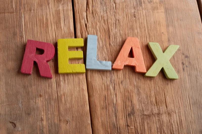 Colorful wooden letters spelling relax arranged on a wooden surface