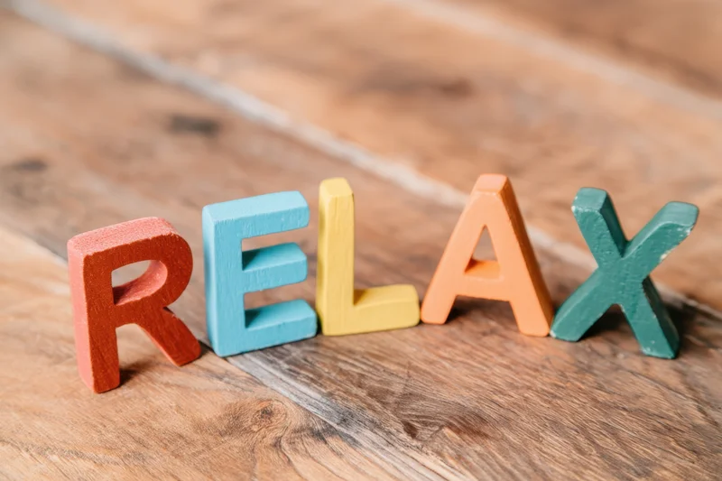 Colorful wooden letters spelling relax arranged on a wooden surface