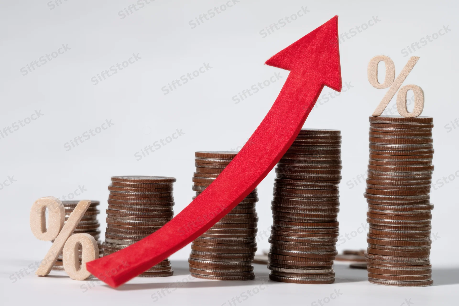 Stacked coins arranged in increasing height with a red arrow pointing upward and percentage symbols on top, on a white background