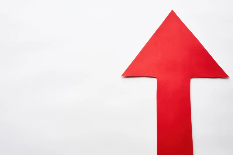 Bold red arrow pointing upward on a clean white background with copyspace