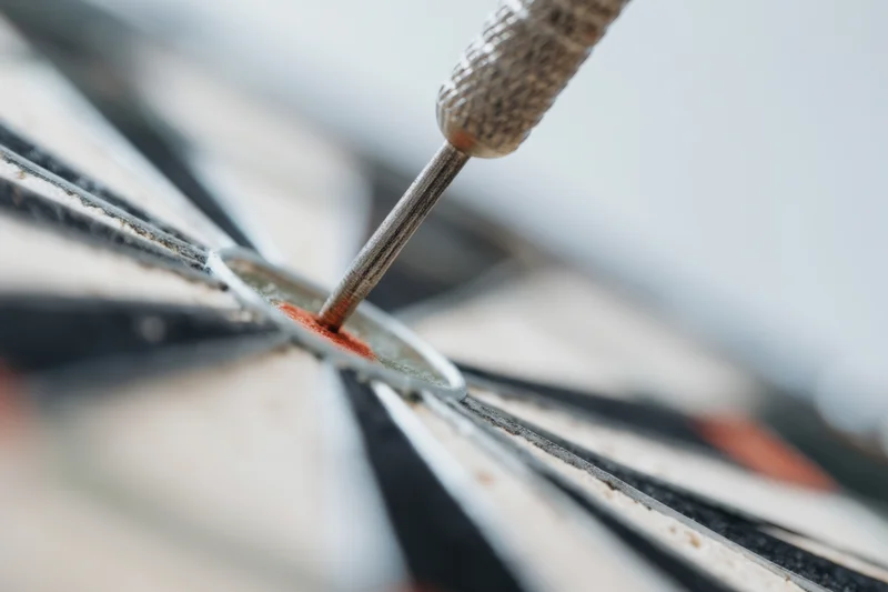 Dart embedded in bullseye of dartboard, close-up view