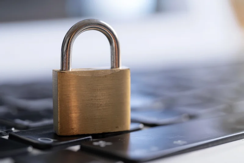 Brass padlock resting on laptop keyboard surface