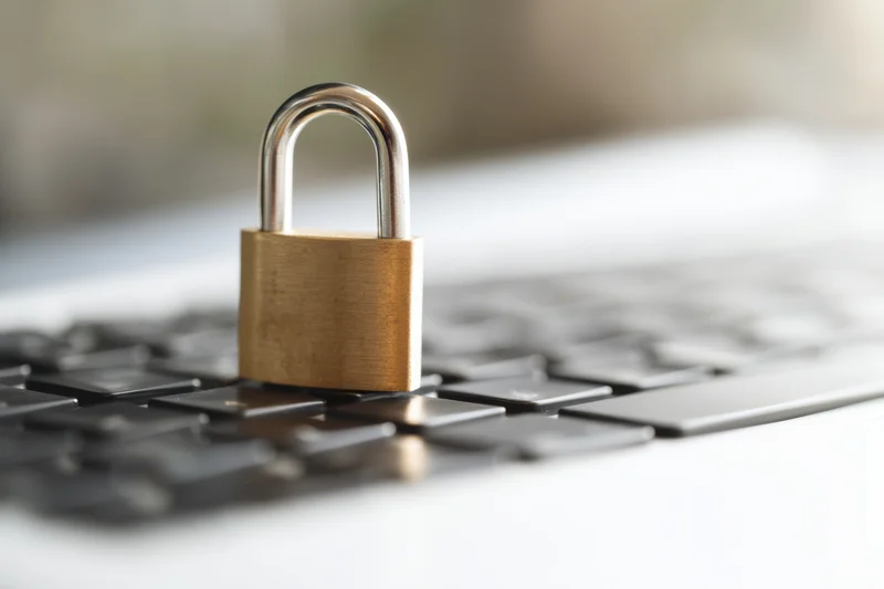 Brass padlock resting on laptop keyboard surface