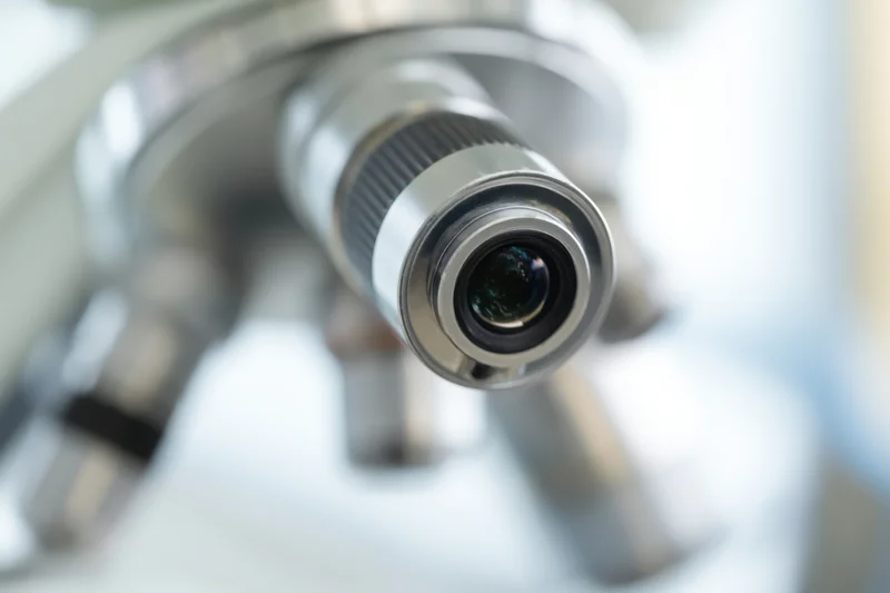 Close-up of a microscope eyepiece lens with shallow depth of field and blurred background