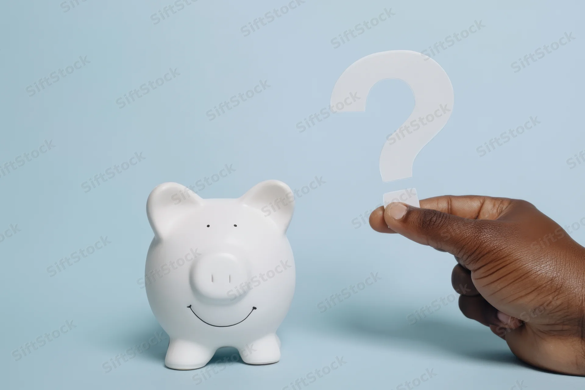 White ceramic piggy bank with smiling face beside a hand holding a question mark against a blue background