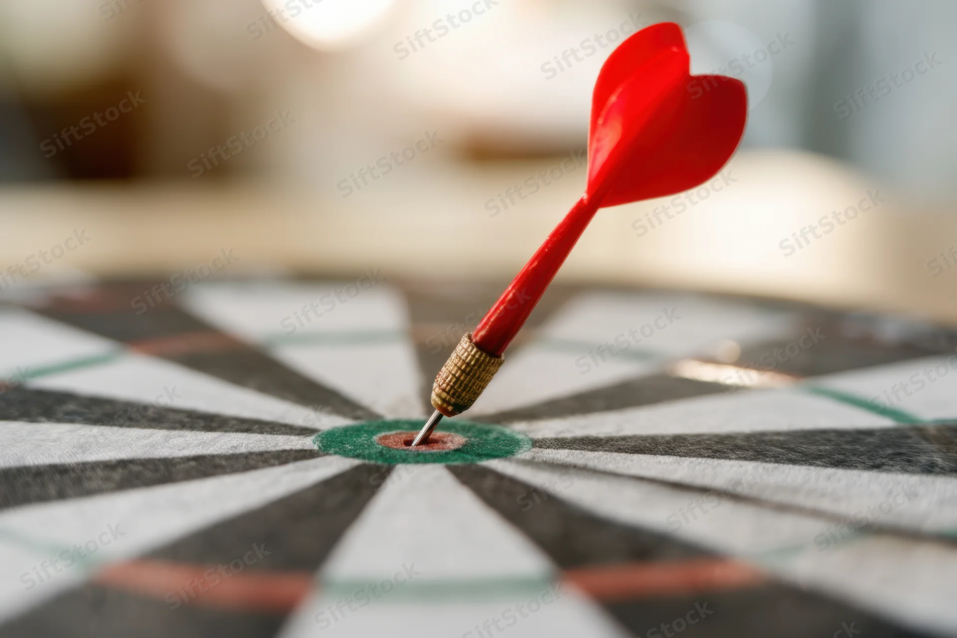 Red heart-shaped dart hitting bullseye on dartboard