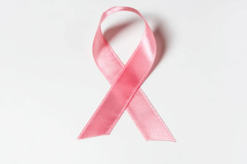 Pink ribbon arranged in loop shape on white background
